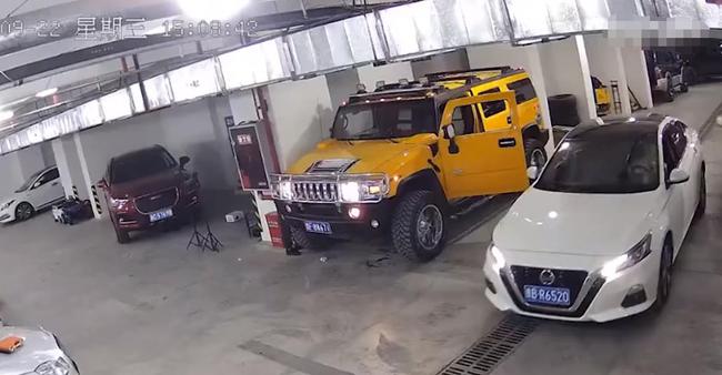 汽修厂3吨重悍马车突然溜车，修车师傅徒手阻挡遭挤压